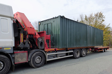 side picture of green container on the hiab lorry
